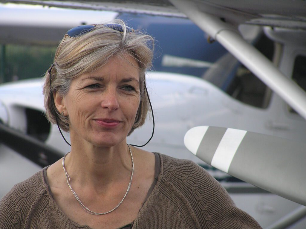 Ute Hölscher, ehem. stellv. Leitung LFS, steht vor einem Kleinflugzeug und blickt freundlich in die Kamera.