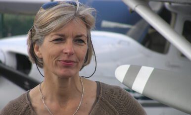 Ute Hölscher, ehem. stellv. Leitung LFS, steht vor einem Kleinflugzeug und blickt freundlich in die Kamera.