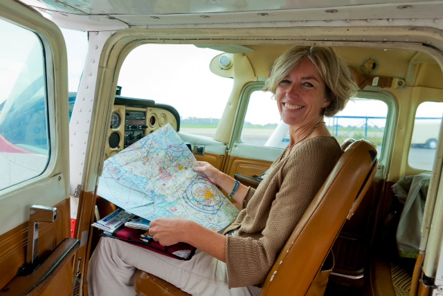 Fliegen ist mein Leben, mein schönster Moment, Fluglehrerin Ute Hölscher, (teilweise mit Flugschüler Matthias), Flugplatz Kiel Holtenau,
Foto: Axel Kirchhof Ute Hölscher, ehem. stellv. Leitung LFS, sitzt im Cockpit eines Kleinflugzeugs mit einer aufgeschlagenen Karte in ihren Händen und blickt freundlich in die Kamera.