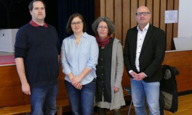 Vier Personen schauen in die Kamera; von links nach rechts: Björn Albrecht, Katharina Bossard De Paz, Nicole Hinsch-Tönnies, Herr Brodersen, im Hintergrund ein Ausschnitt einer Aula.