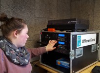 Hier lege ich die CDs für die Musik, die später im Radio gespielt werden soll, in den Player. Schülerin vor Abspielgeräten des Offenen Kanals