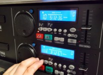 Die Schalter am Player sind mit Kontrasten gestaltet und mit Punktschrift gekennzeichnet. Finger an einem CD Player