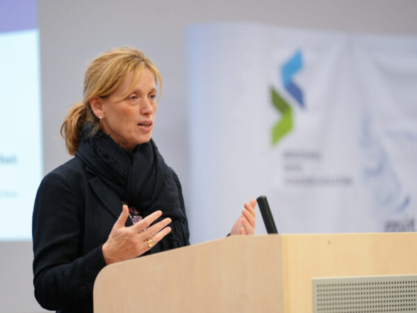 Bildungsministerin Karin Prien gestikulierend vor einem Rednerpult. Im Hintergrund ist das Logo des Berufswahlsiegels zu sehen.