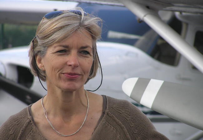 Ute Hölscher, ehem. stellv. Leitung LFS, steht vor einem Kleinflugzeug und blickt freundlich in die Kamera.