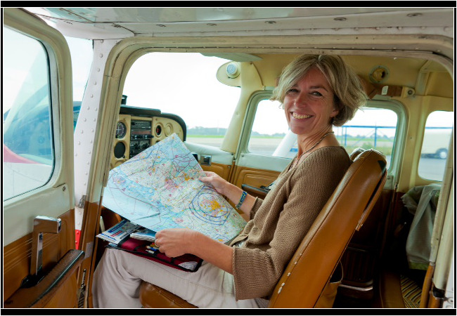 Fliegen ist mein Leben, mein schönster Moment, Fluglehrerin Ute Hölscher, (teilweise mit Flugschüler Matthias), Flugplatz Kiel Holtenau,
Foto: Axel Kirchhof Ute Hölscher, ehem. stellv. Leitung LFS, sitzt im Cockpit eines Kleinflugzeugs mit einer aufgeschlagenen Karte in ihren Händen und blickt freundlich in die Kamera.